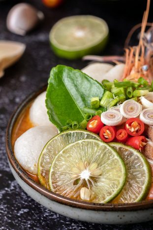 Tom Yum Kung in a bowl with tomato, chili, lemongrass, garlic, l